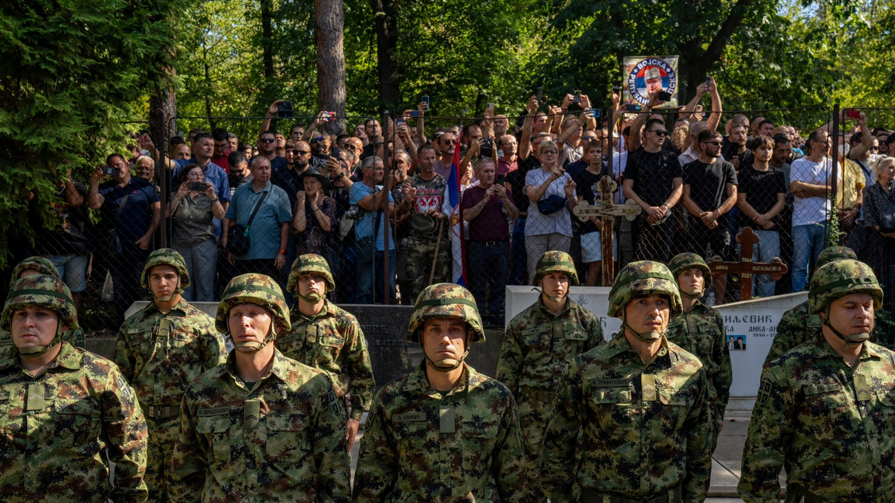 Vojska stoji, iza njih ljudi