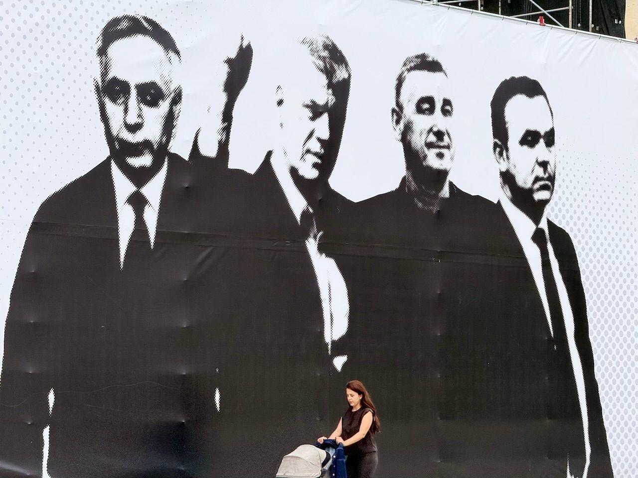 Poster četvorice muškaraca i žena koja gura bebu u kolicima 