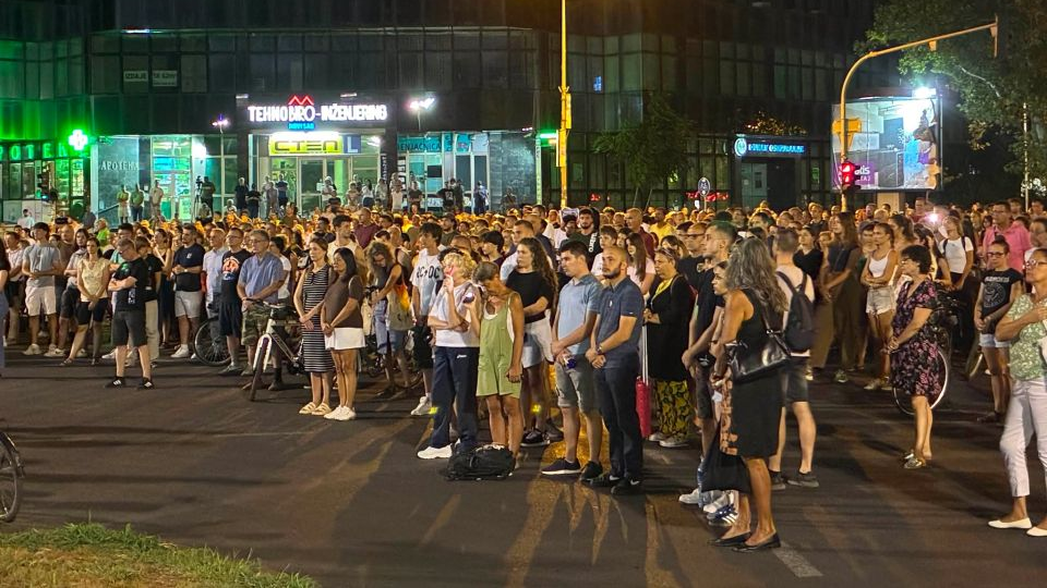 Ljudi stoje u miru i tišini na ulici po noći